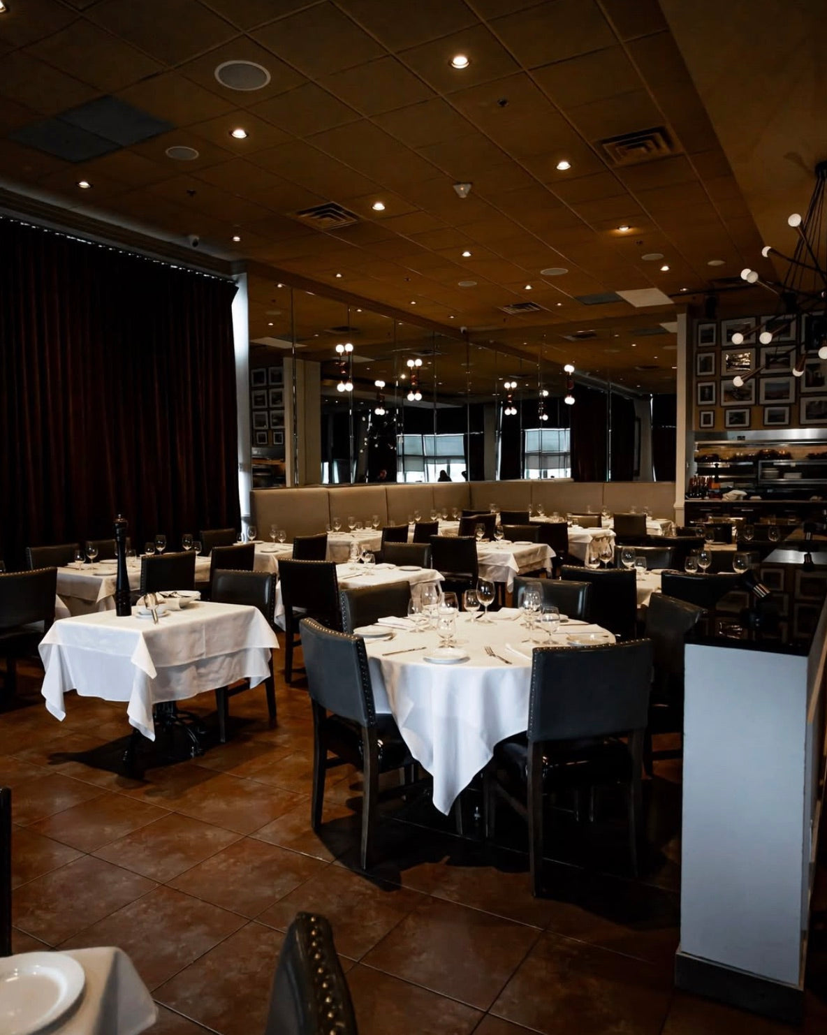 Salle à manger privée — nappes blanches et fauteuils de cuir sombre