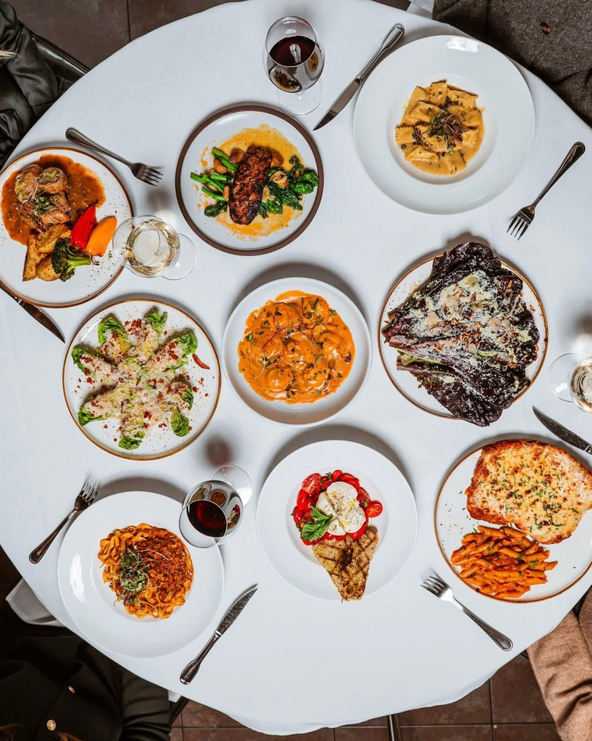 Grande tablée dressée en partage — plats italiens servis en famille et vin