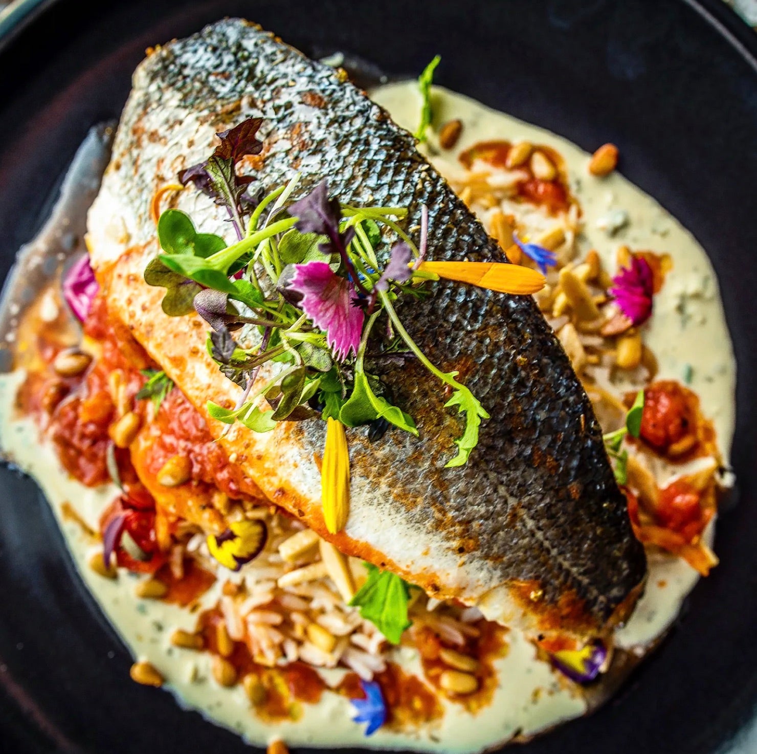 Bar entier rôti, herbes et pignons — un plat signature